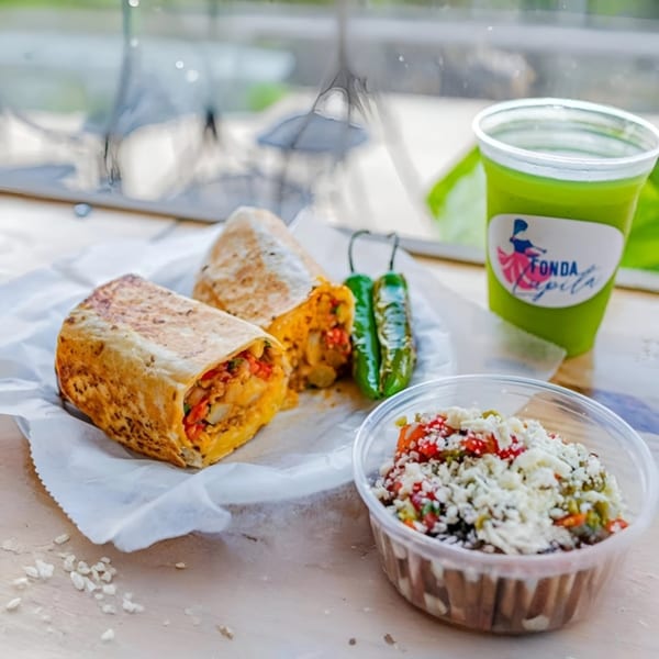 Two burritos, two green peppers, a side salad, and a green drink with the Fonda Lupita logo.